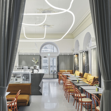 Stylish interior of Café Bellaria featuring modern lighting, seating areas, and a welcoming coffee ambiance in Vienna.
