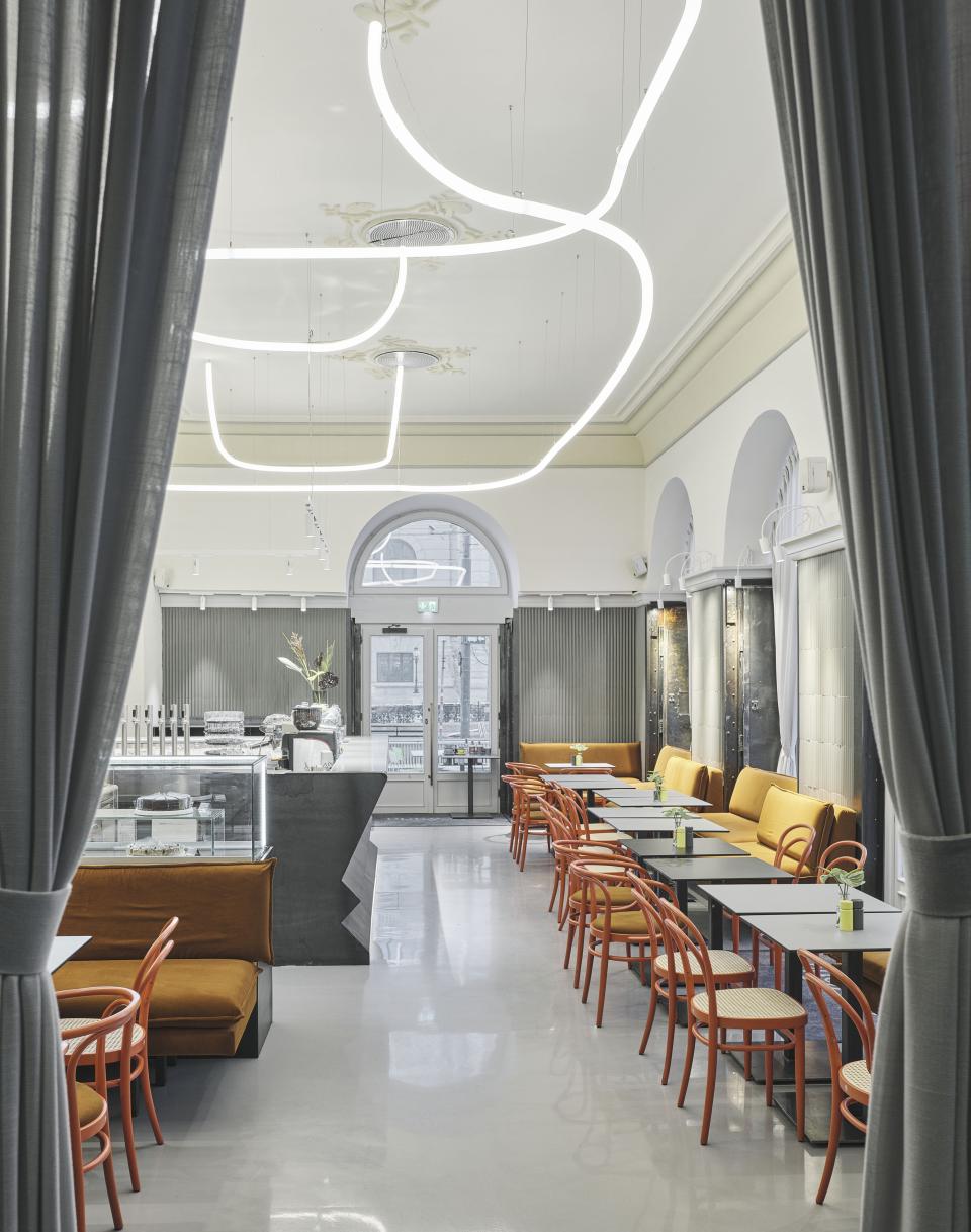 Stylish interior of Café Bellaria featuring modern lighting, seating areas, and a welcoming coffee ambiance in Vienna.