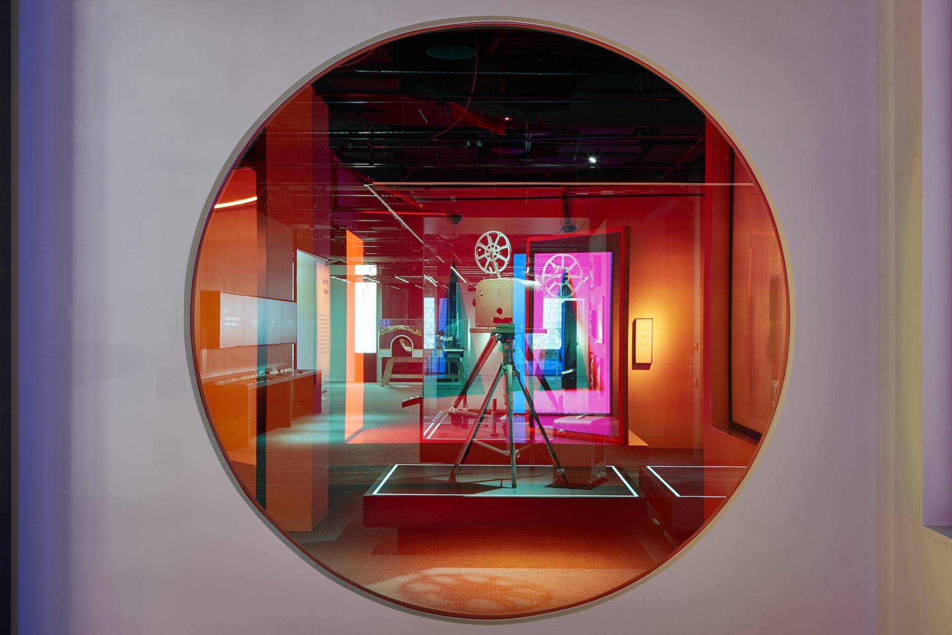 Colorful interior of ACMI museum featuring a vintage film projector and interactive displays showcasing screen culture.