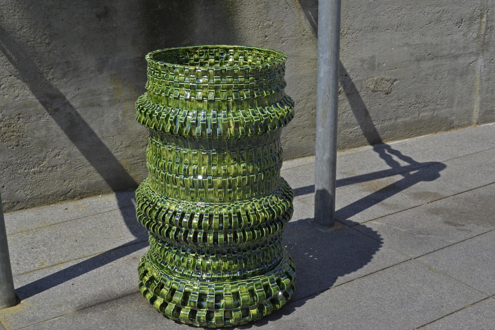 Green, woven textile sculpture by Freyja Dorren, showcasing innovative design in urban art installation.
