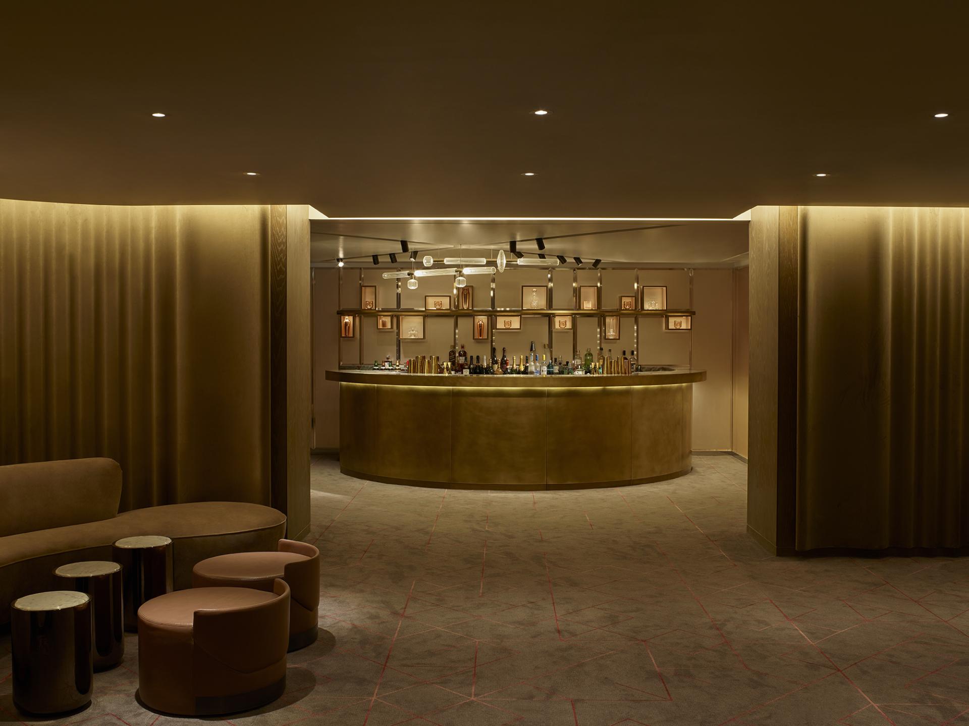 Sophisticated hotel bar interior featuring a curved golden counter, ambient lighting, and elegant furnishings at Leicester Square.
