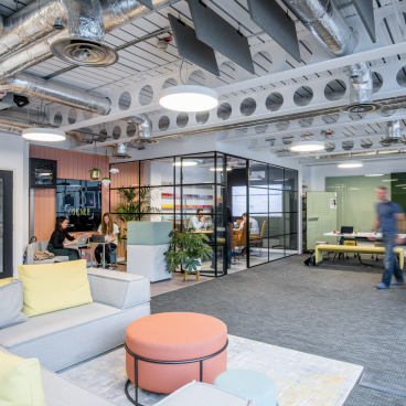 Modern showroom showcasing Woven Image's recycled acoustic panels, featuring collaborative workspaces and vibrant, comfortable furnishings.