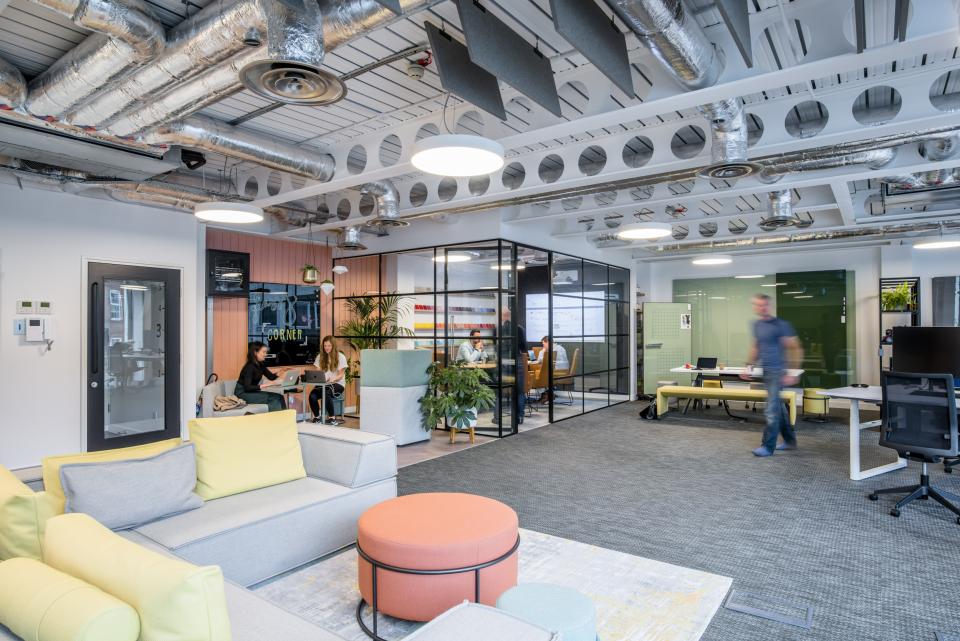 Modern showroom showcasing Woven Image's recycled acoustic panels, featuring collaborative workspaces and vibrant, comfortable furnishings.