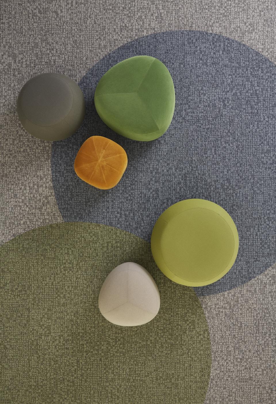 Colorful, irregularly shaped seating elements on a patterned floor, showcasing Tarkett DESSO's Orchard collection design.