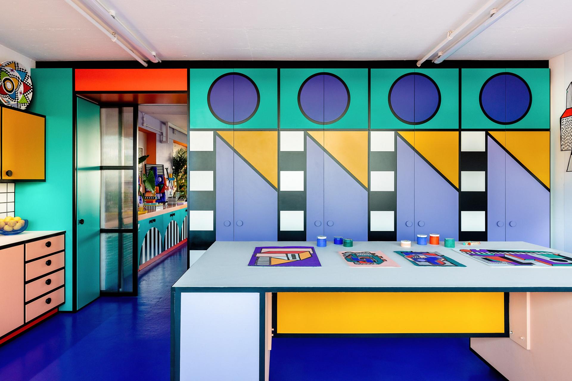 Colorful studio interior featuring bold geometric patterns on cabinets and a vibrant workspace, showcasing Camille Walala's artistic style.