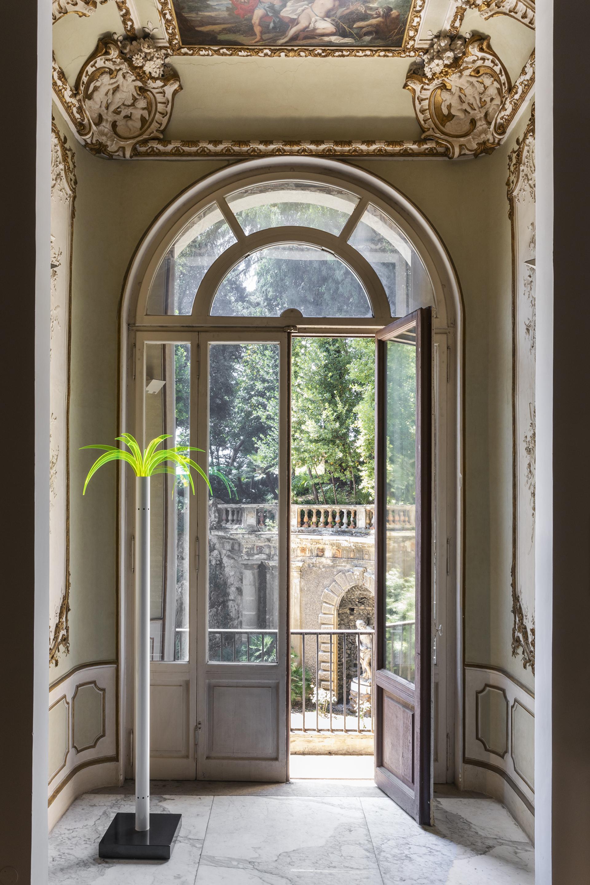 Bright interior of Palazzo Brancaccio featuring an open door, ornate ceiling, and a modern art installation.