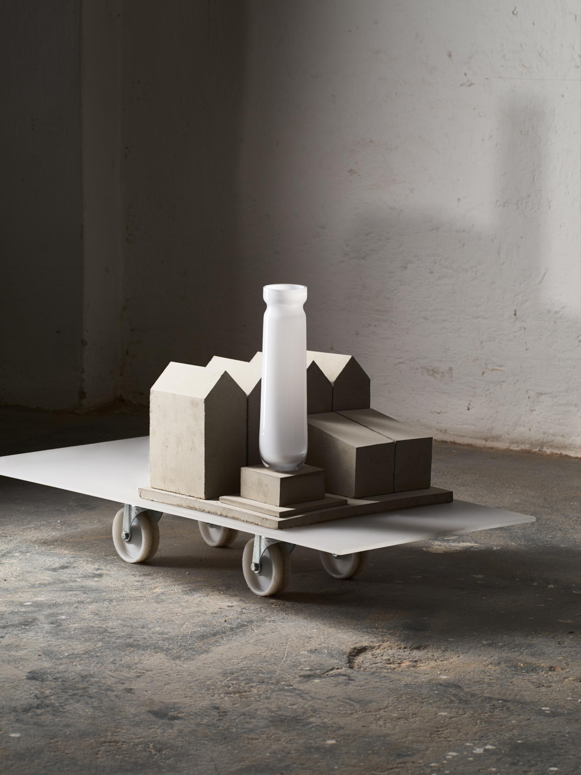 Contemporary glass and concrete sculpture on a rolling cart, exemplifying innovative design at the London Design Fair.