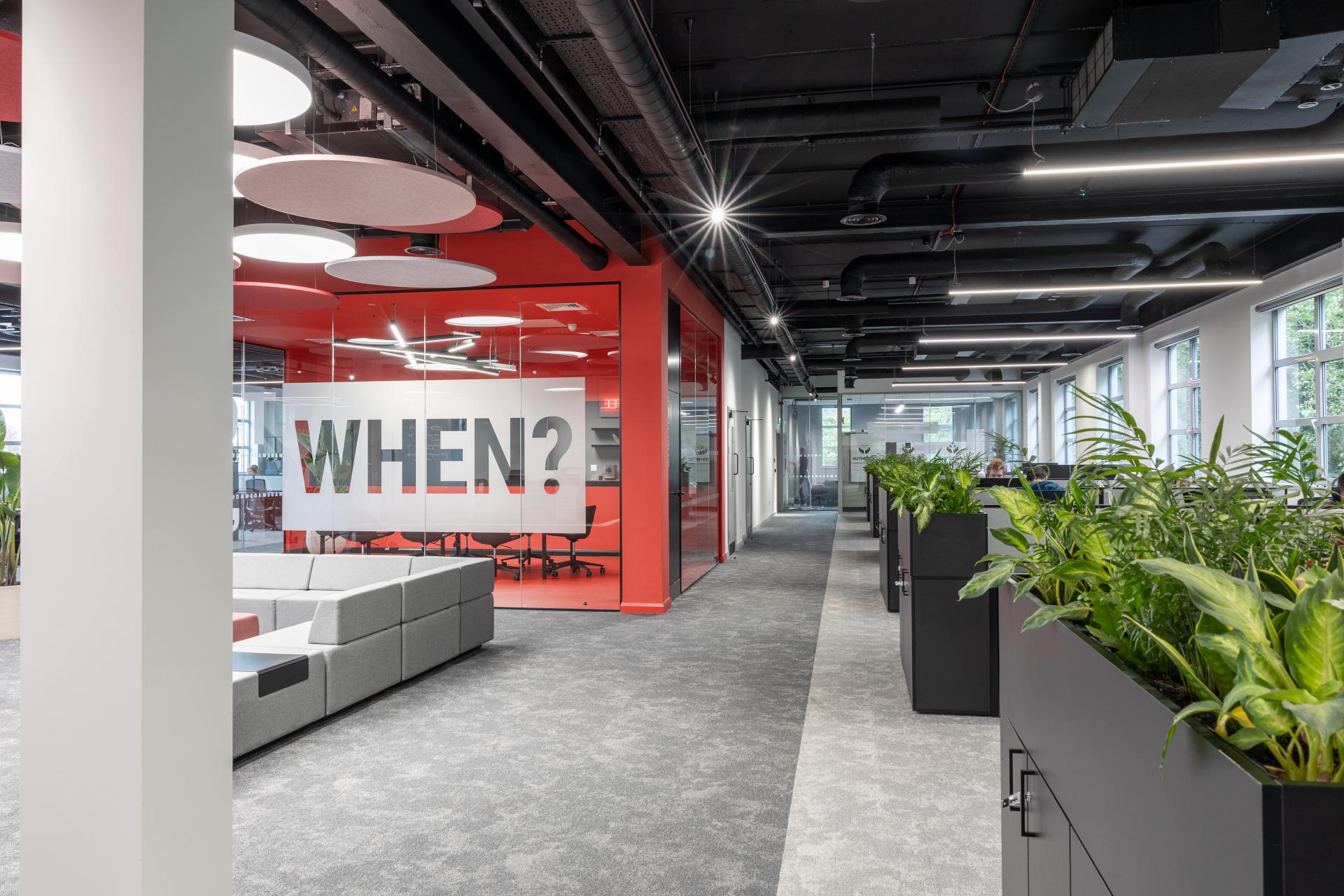 Modern office interior of M1NT Studio featuring collaborative spaces and greenery, highlighting innovative design and interactive communication.