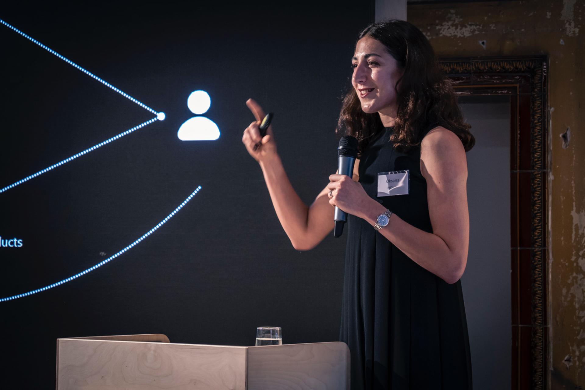 Speaker passionately discussing biomimetic design principles during the From The Ground Up exhibition event.