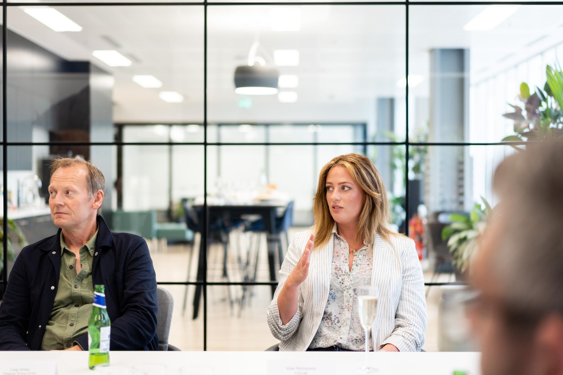 Business professionals engaged in a discussion in a modern office environment, highlighting collaborative technology in the workplace.