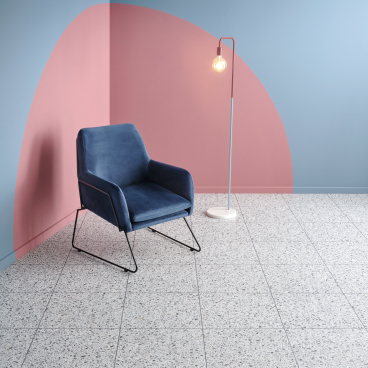 Stylish lounge setup featuring Amtico's Spacia luxury vinyl tile, a modern chair, and contemporary wall colors.