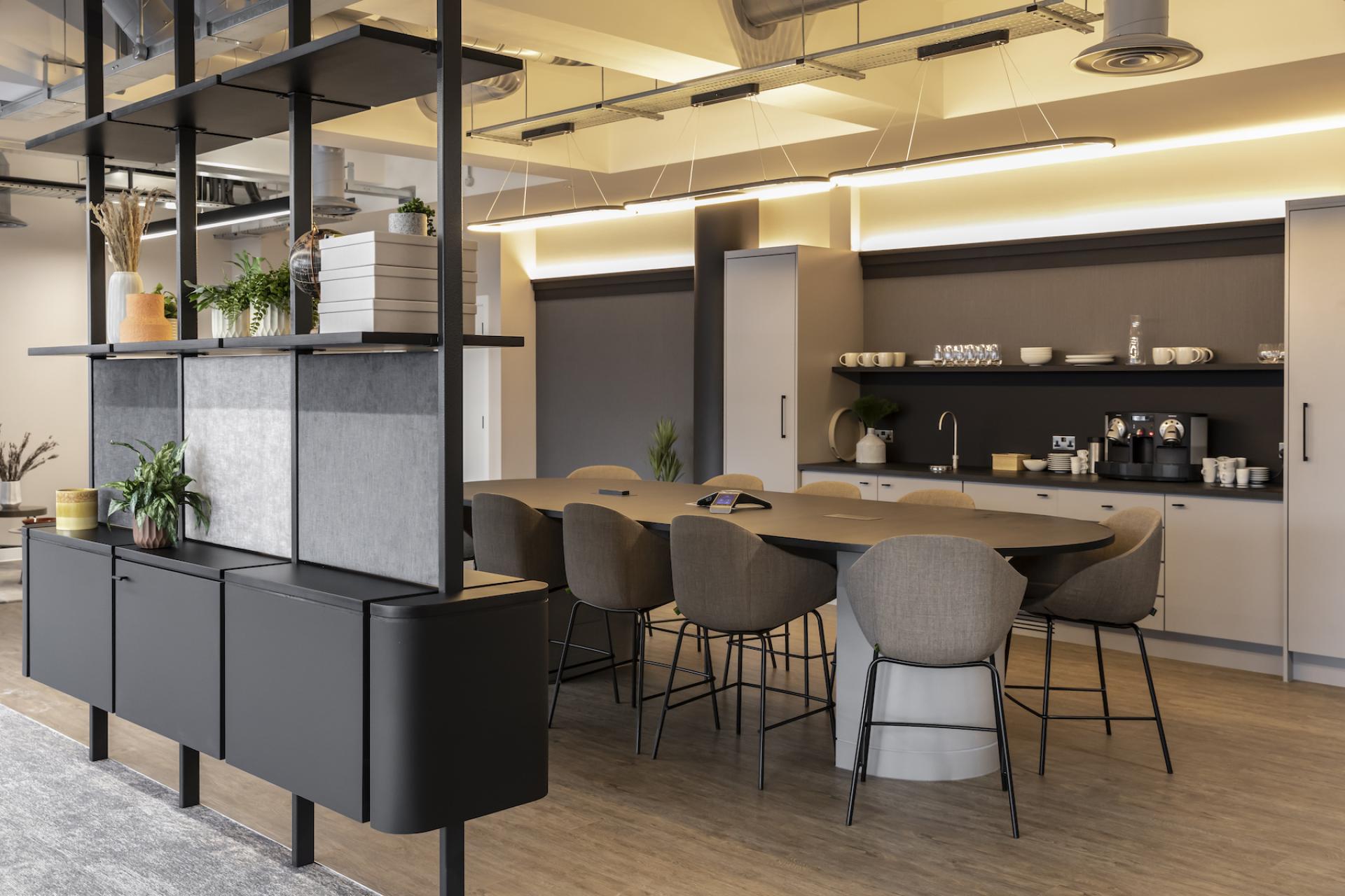 Modern workspace featuring a stylish kitchen area and collaborative dining table designed by SpaceInvader for Tosca Debt Capital.