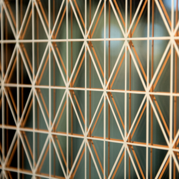 Intricate geometric pattern featuring white and copper lines, showcasing innovative surface design from the Surface Design Show 2020.
