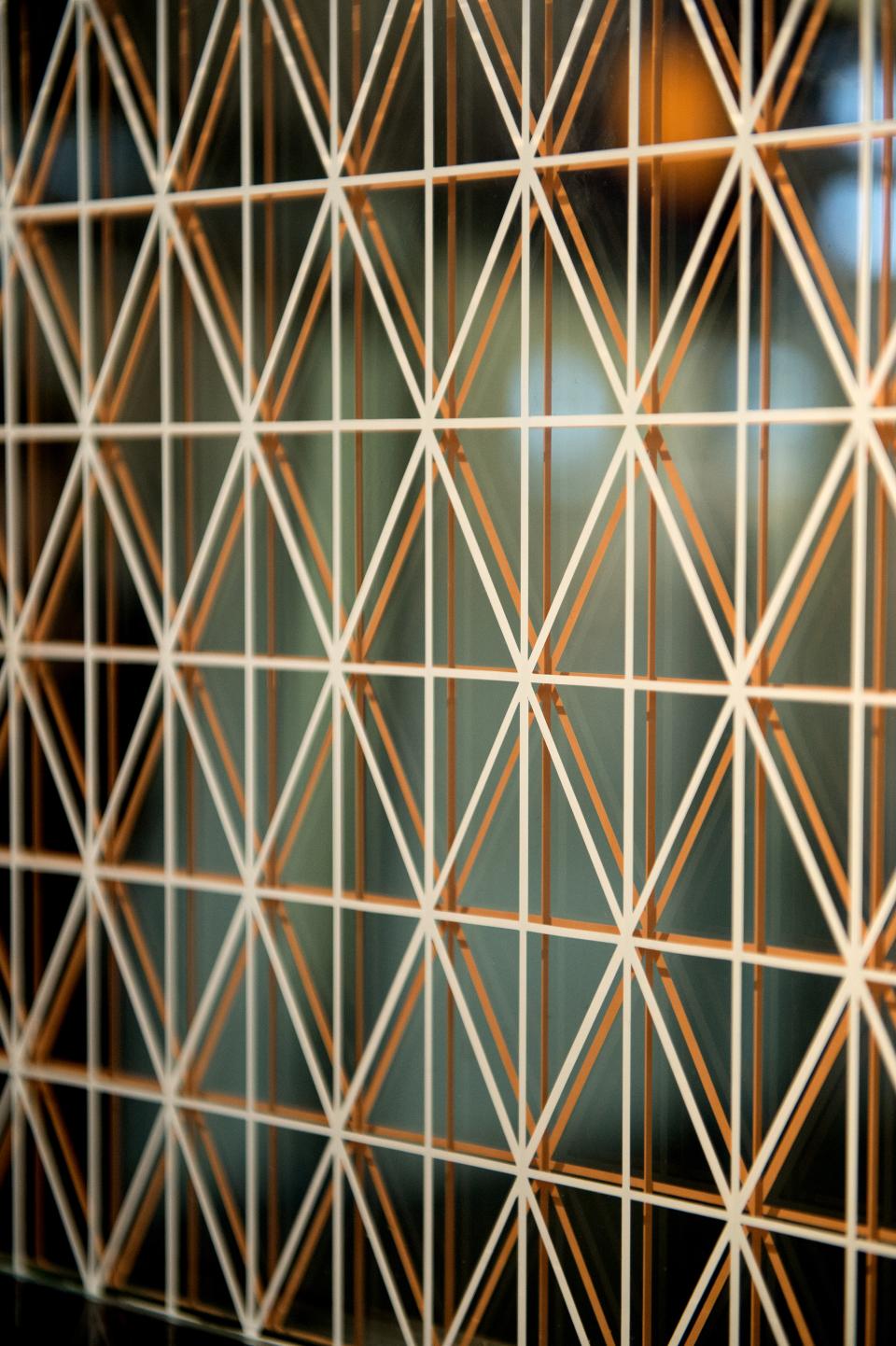 Intricate geometric pattern featuring white and copper lines, showcasing innovative surface design from the Surface Design Show 2020.