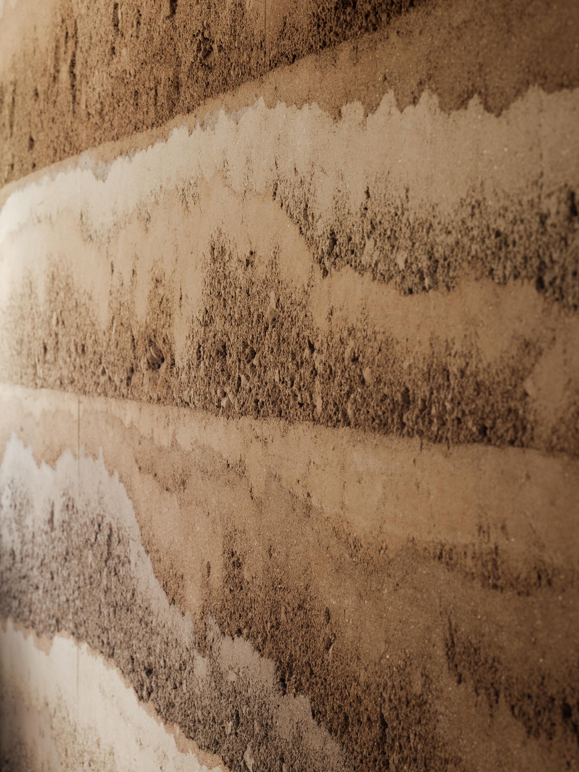 Natural rammed earth wall texture featuring layered tones, showcasing sustainable design principles by Clayworks’ Rammed Earth range.