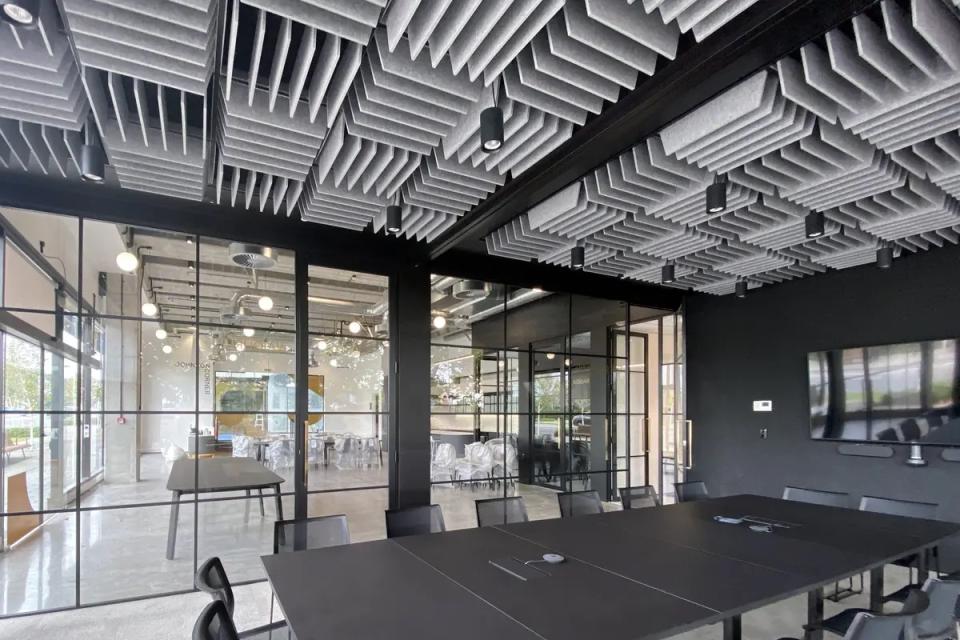 Innovative Autex acoustic ceiling tiles create a striking sculptural design in a modern conference room setting.