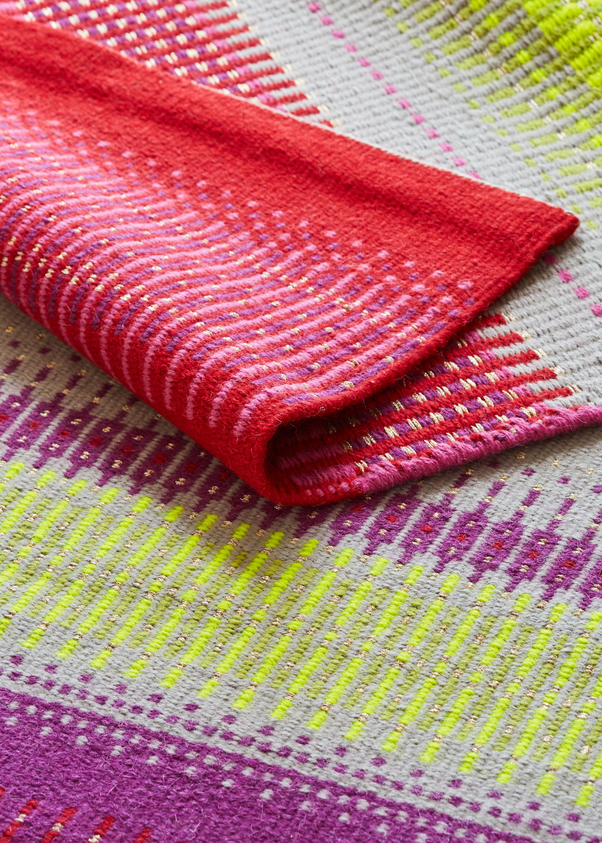 Vibrant Scandinavian textile showcasing bold red, pink, and yellow patterns, highlighting contemporary design aesthetics for Decorex International.