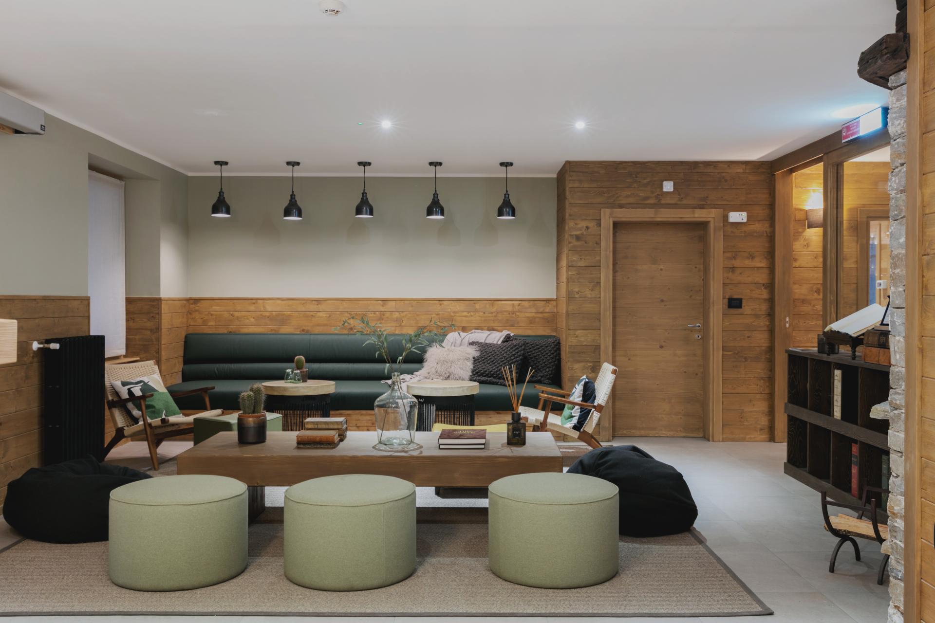 Modern lounge area in a sustainable Italian hotel featuring natural wood accents, comfortable seating, and stylish decor.