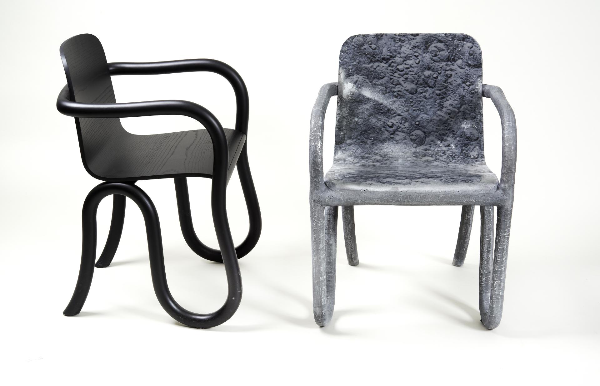 Two modern chairs, one black and sleek, the other textured like the moon’s surface, showcasing innovative design inspired by lunar themes.
