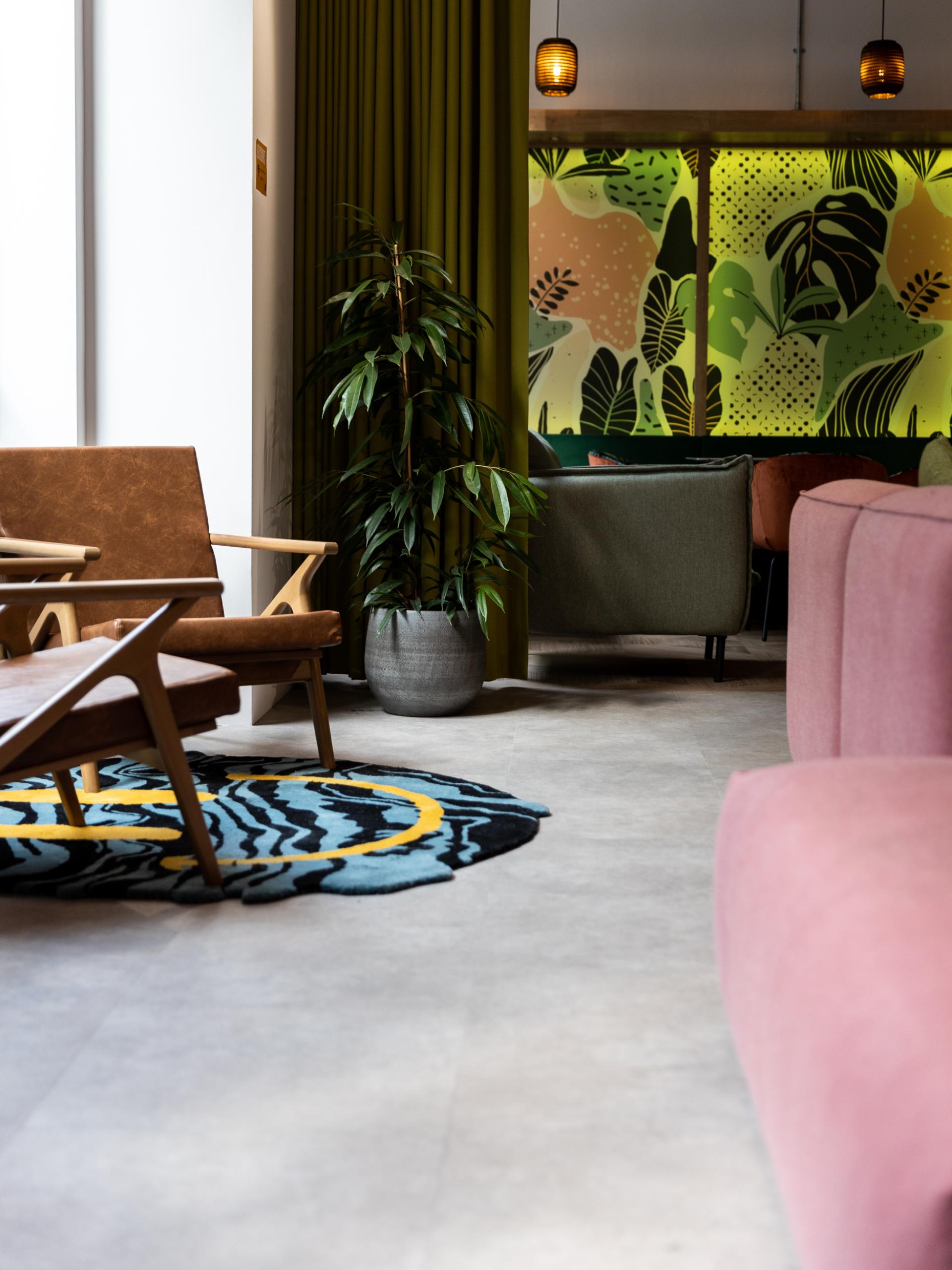 Stylish interior featuring vibrant patterns, cozy seating, and a decorative plant in a modern co-working space.