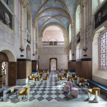 Interior of The Jaffa, showcasing John Pawson's minimalist design, featuring elegant seating and stunning stained glass windows.