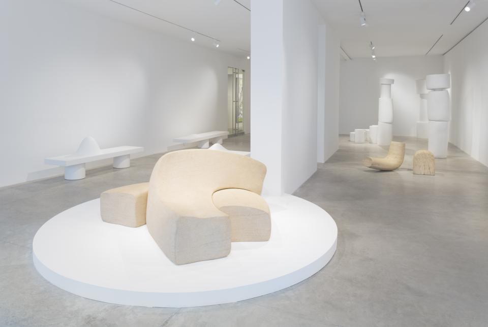 Unique sculptural furniture pieces by Wendell Castle displayed in a minimalist gallery setting, emphasizing organic design.