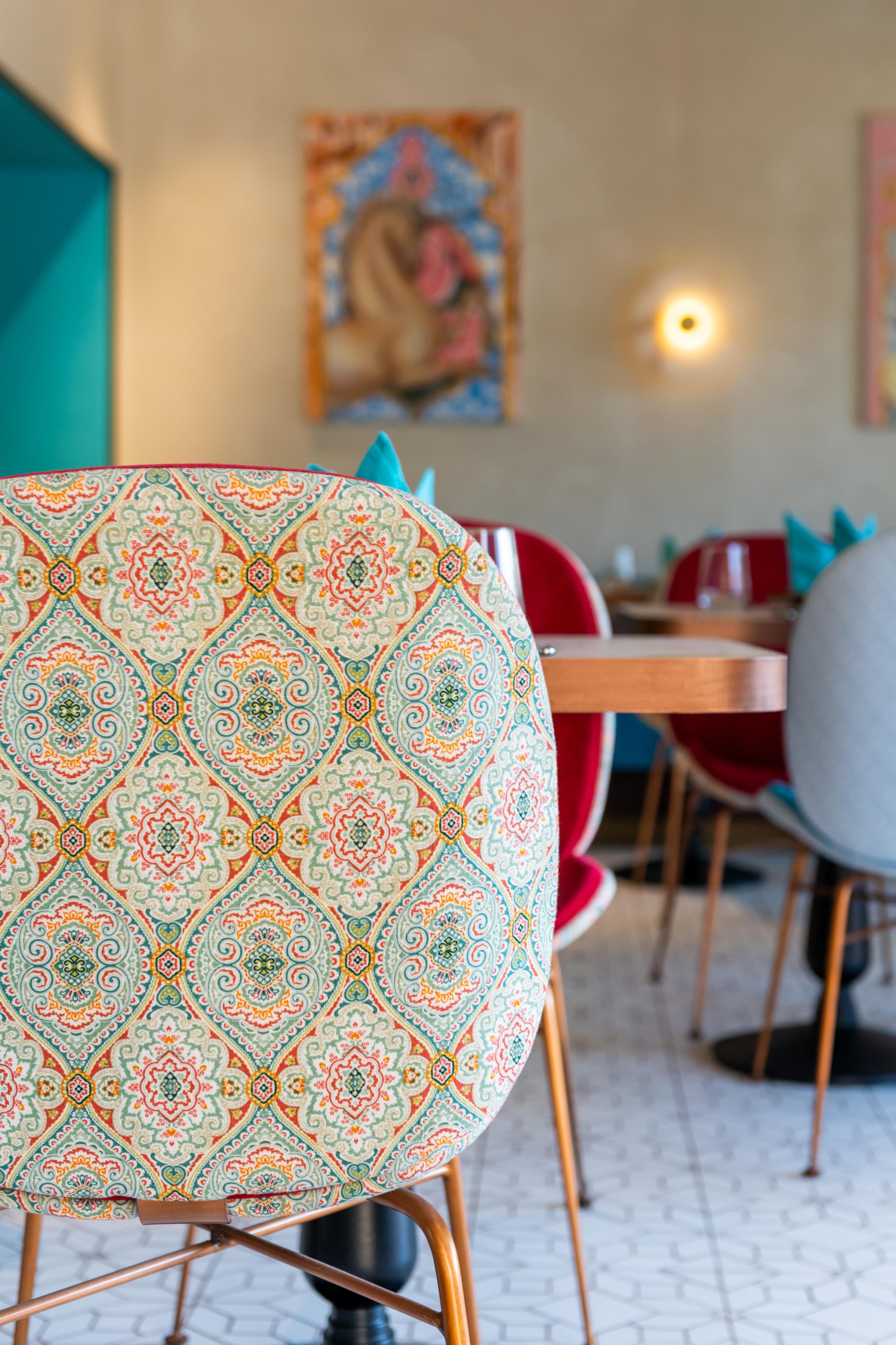 Colorful Persian-patterned chair at Anar restaurant, showcasing the interior design of H2R DESIGN in Dubai.