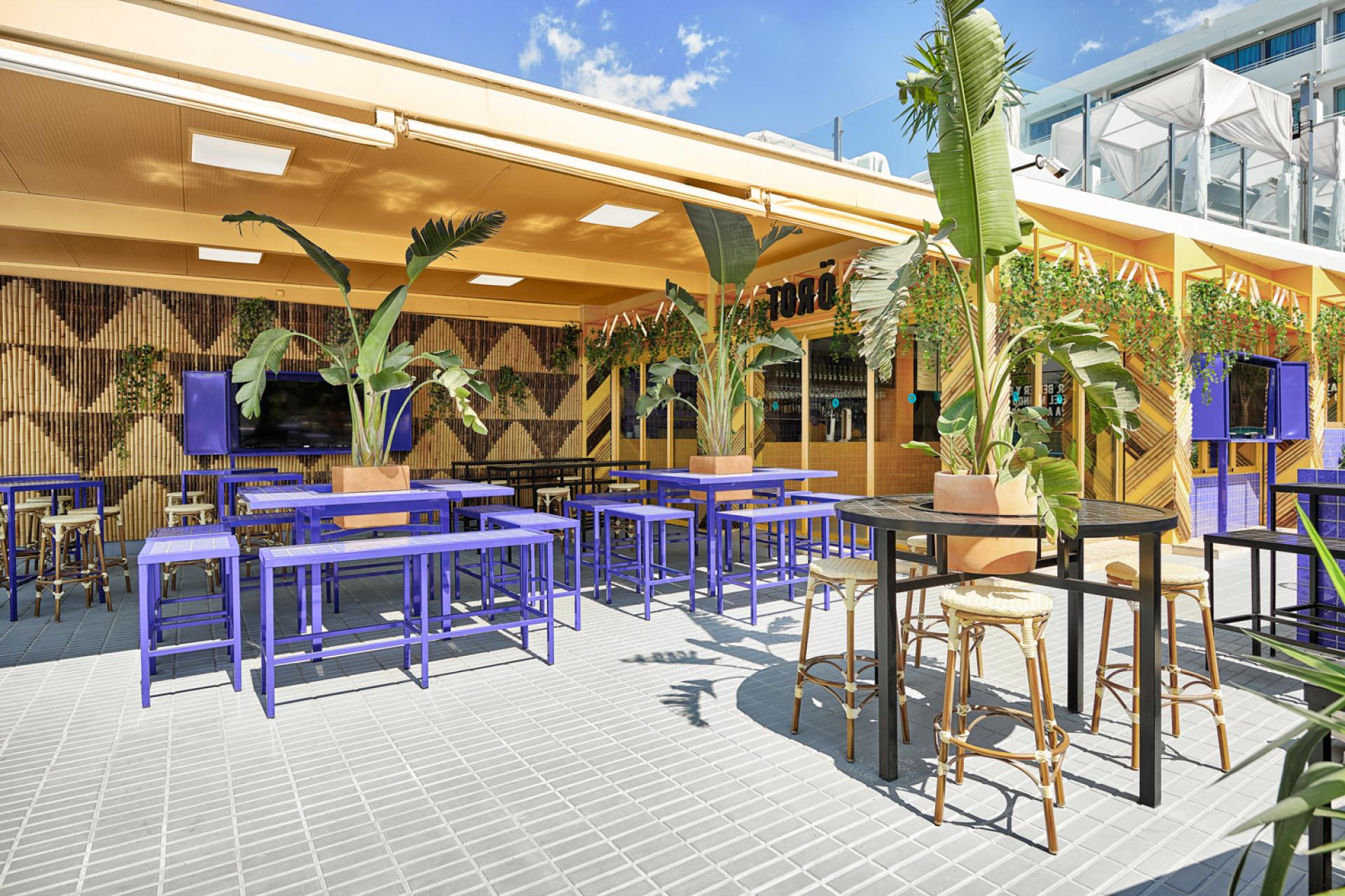 Vibrant outdoor seating area of Bar TORÖ in Ibiza, featuring Mediterranean-inspired design and colorful furniture.