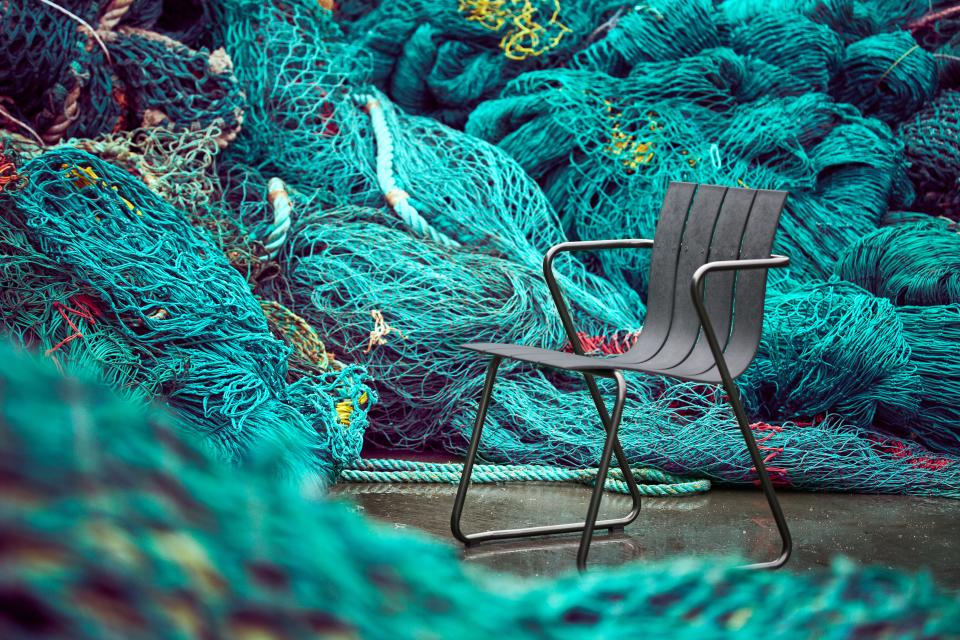 Sleek black chair designed by Jørgen and Nanna Ditzel, set against vibrant fishing nets in the Ocean Collection.