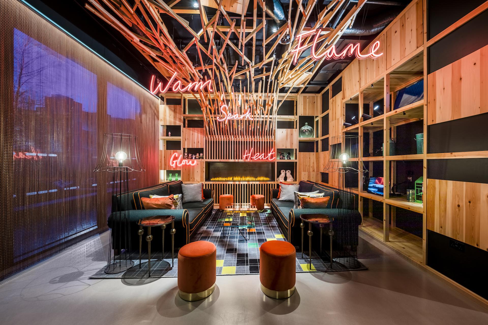 Stylish lounge area in nhow London with neon signs, wooden accents, and modern seating reflecting contemporary design trends.