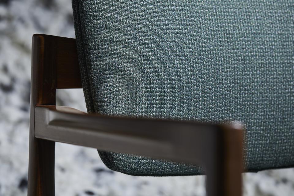 Close-up of a chair back upholstered with Camira's Main Line Twist tweed, showcasing its unique wool and flax texture.