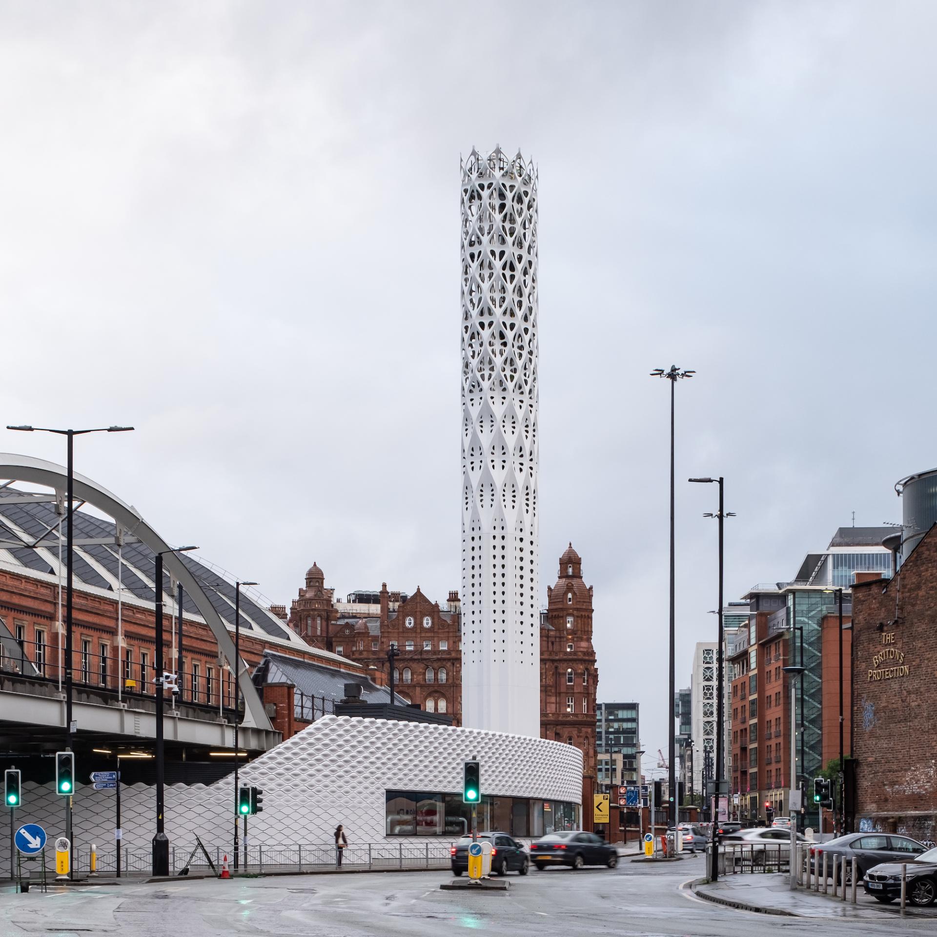 Tower of Light in Manchester, showcasing modern architecture alongside historic buildings, symbolizes the city's zero-carbon ambitions.
