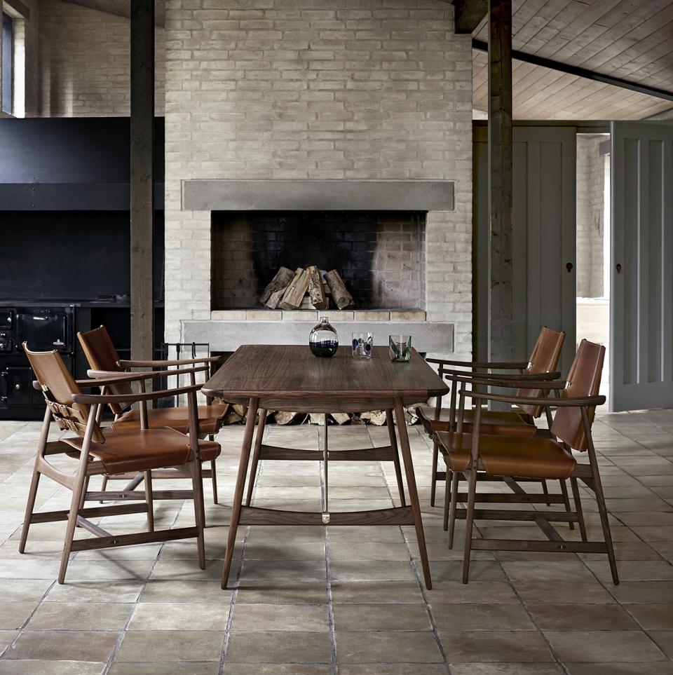 Børge Mogensen’s Huntsman Chairs surround a wooden dining table in an elegant rustic interior setting.