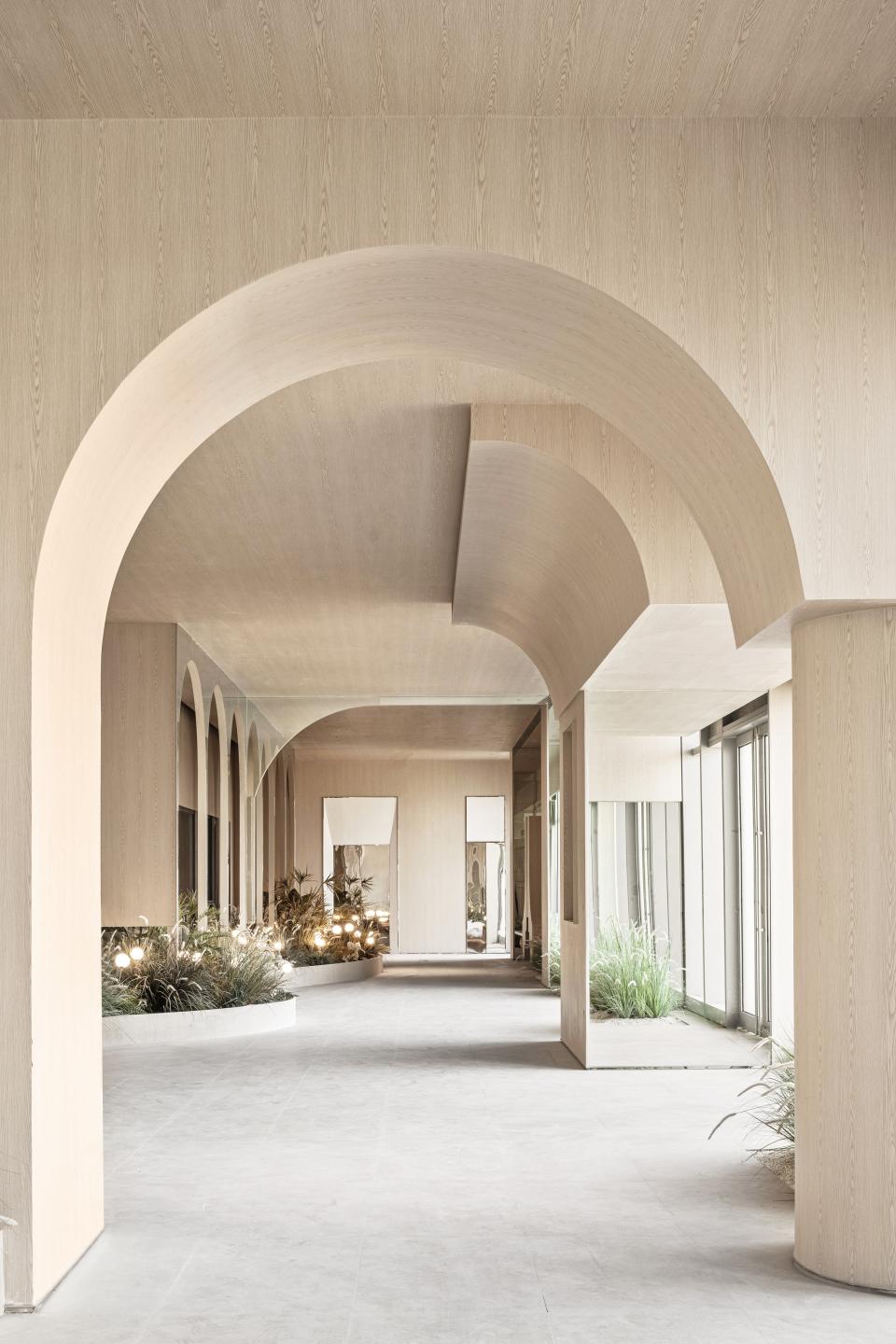 Spacious interior of the Rhythm community centre featuring arched architecture, natural light, and greenery for an urban oasis.