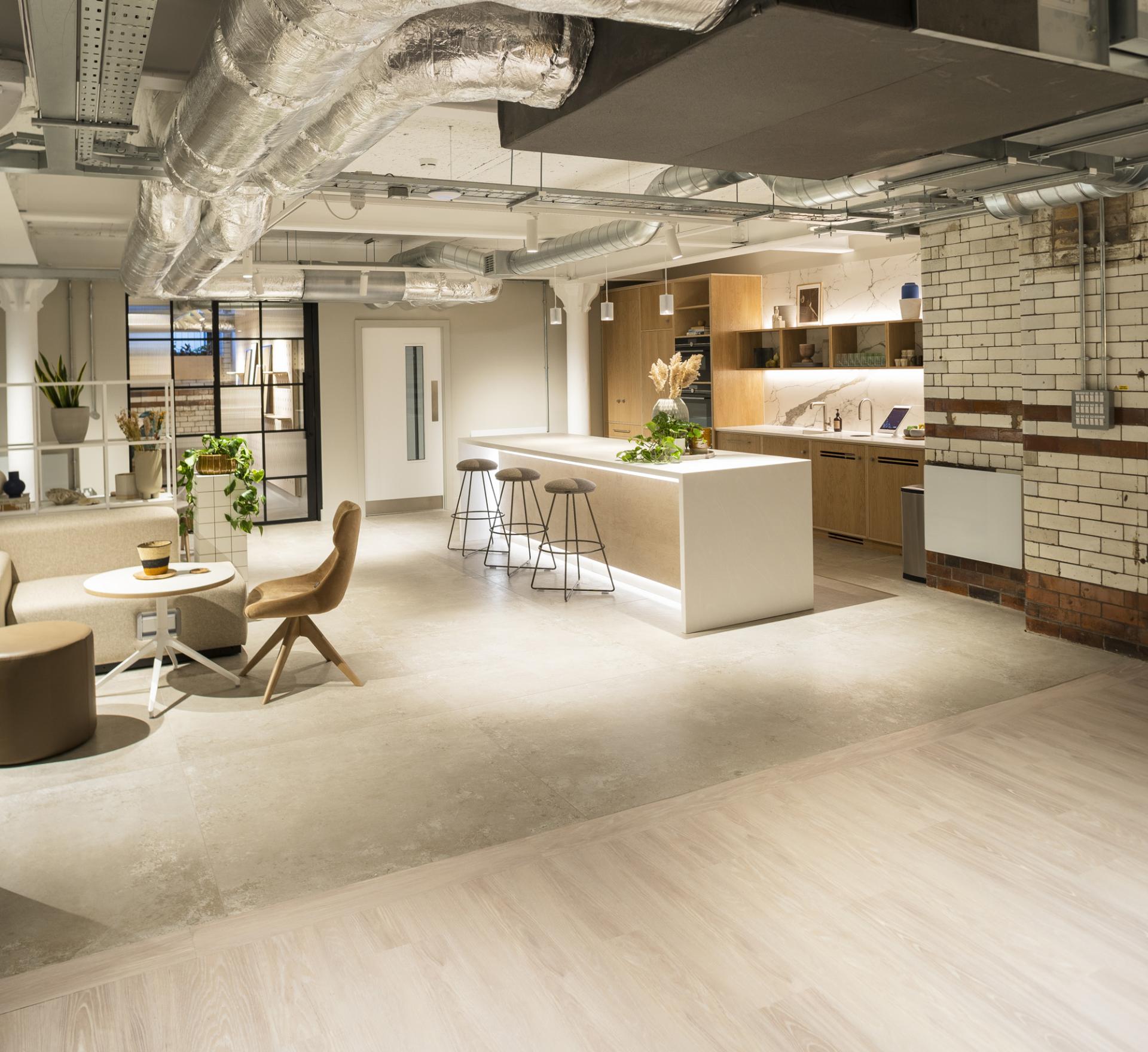 Modern interior of Material Source Studio in Manchester, featuring a cozy seating area, a stylish kitchen, and industrial design elements.