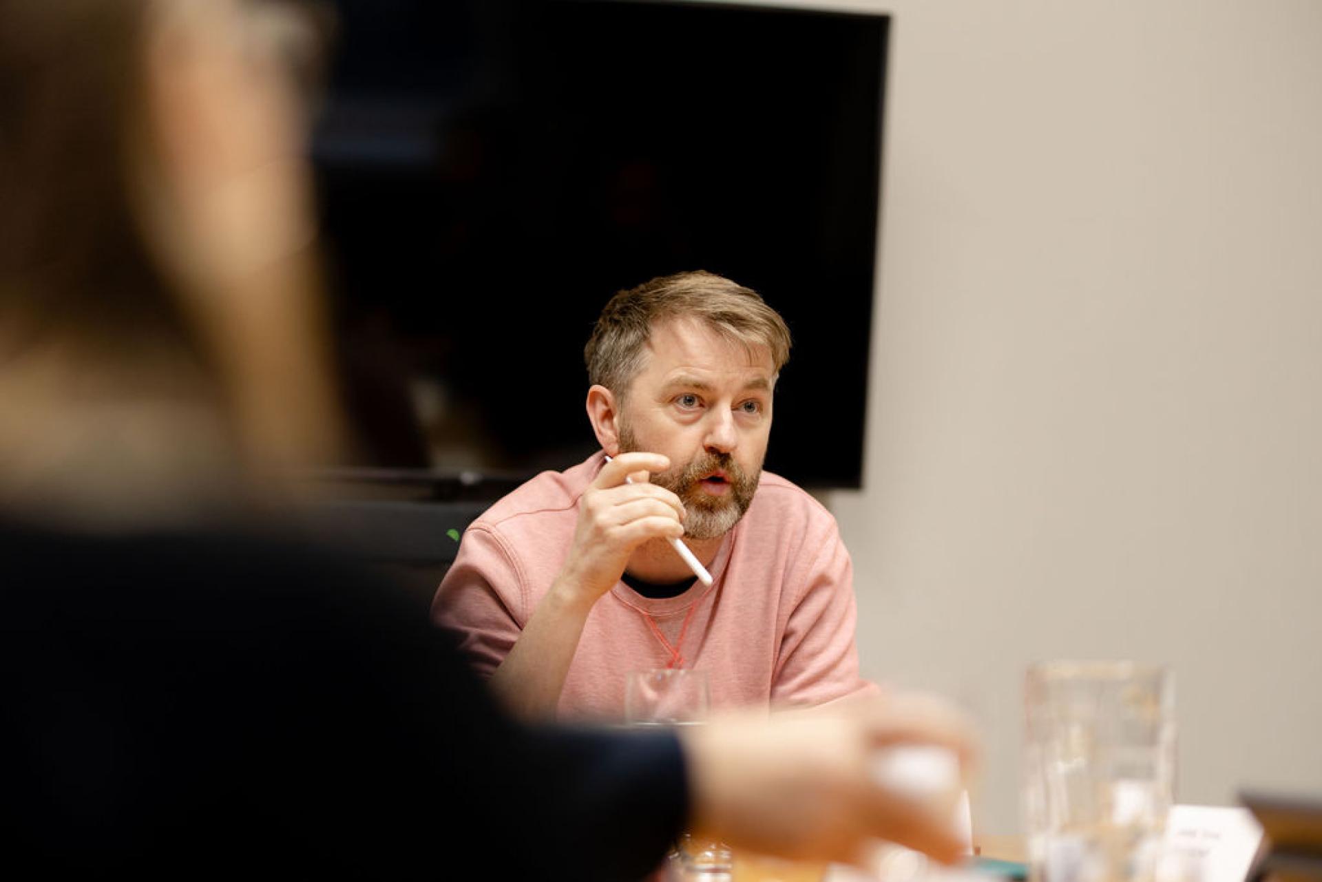 Participant discussing Glasgow's property outlook during a seminar, with glasses and documents on the table.