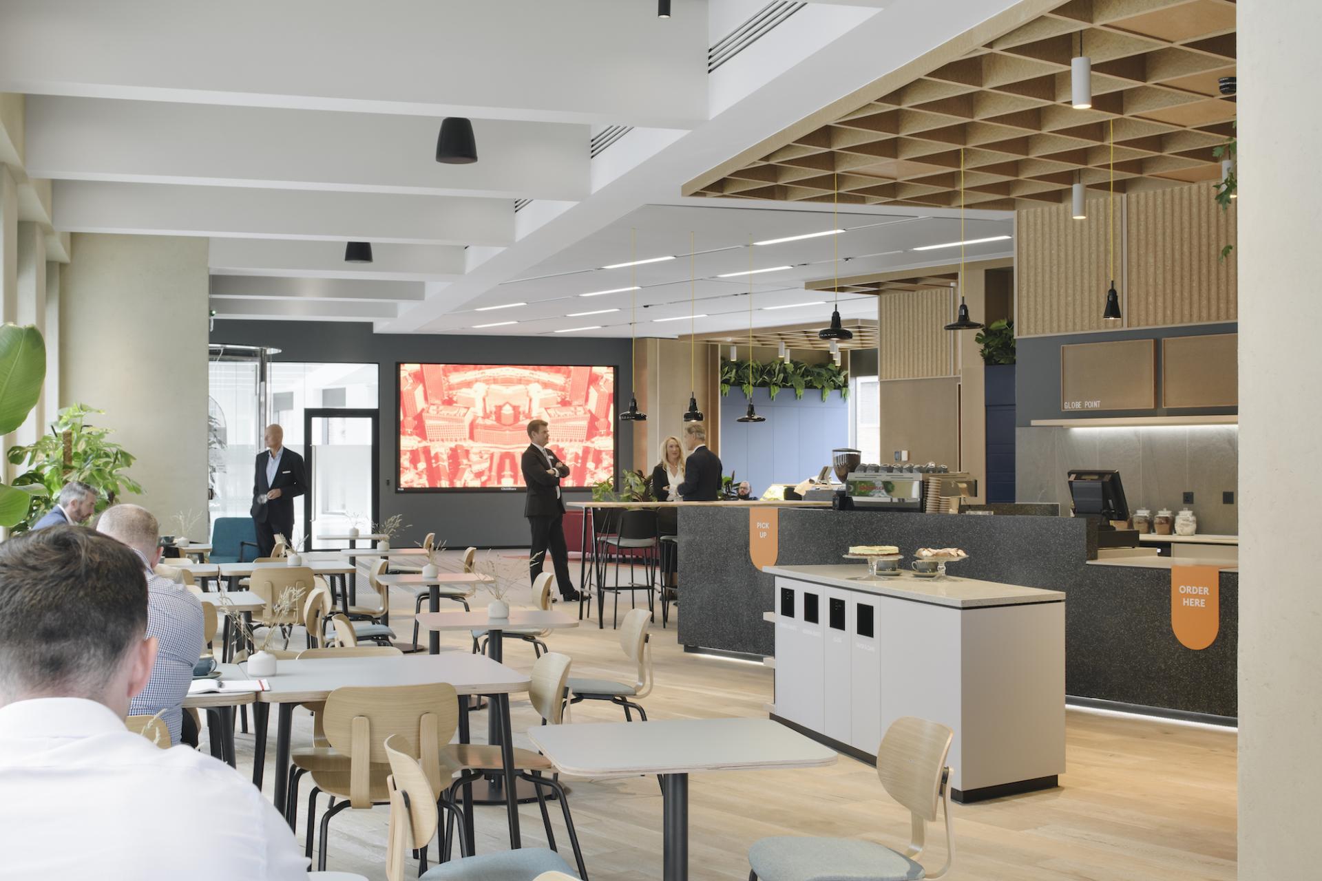Modern café space at Globe Point, Leeds, designed by Ekho Studio, featuring digital displays and inviting interiors.