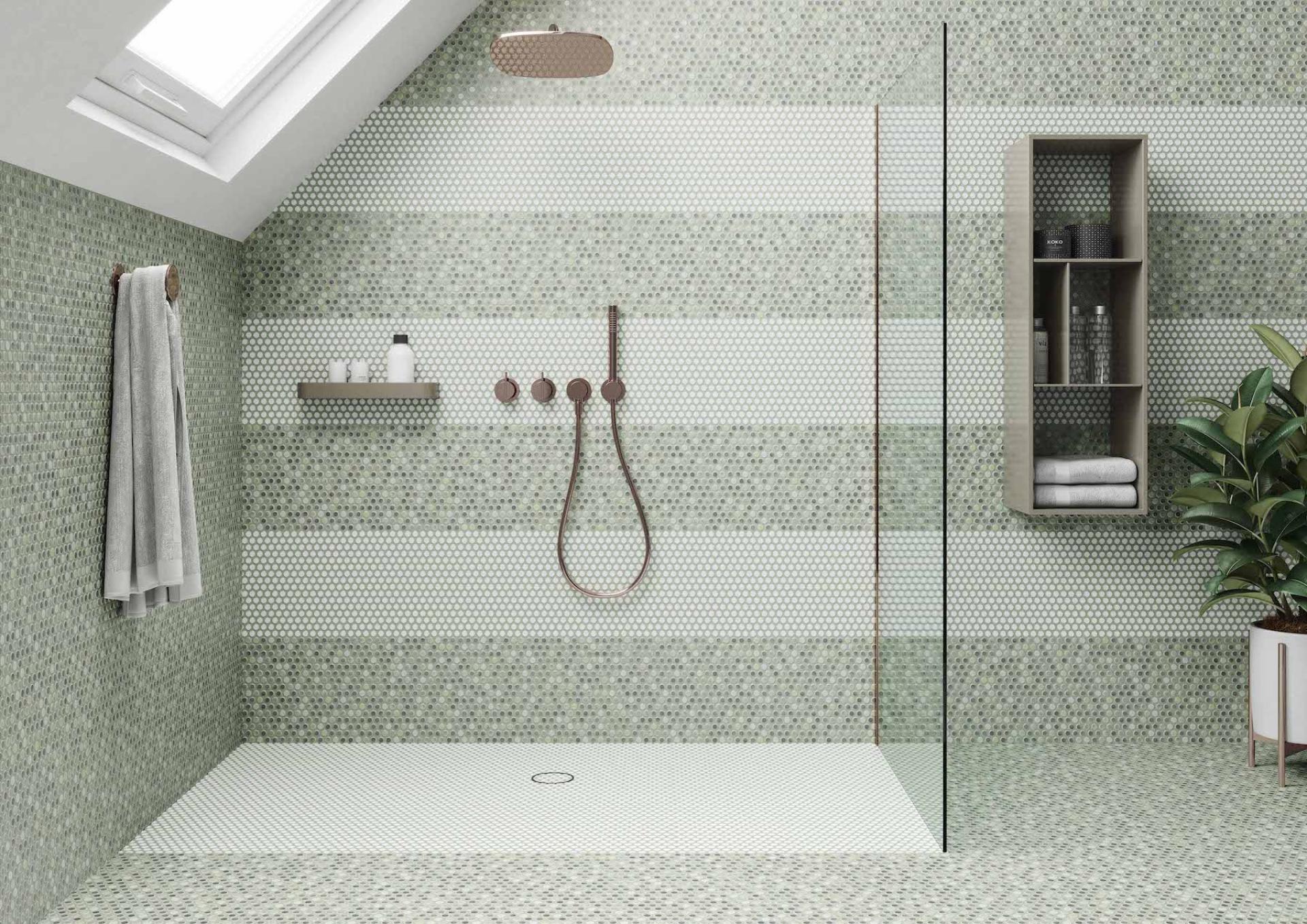 Modern bathroom featuring green hexagonal tiles, a glass shower, and stylish storage, showcasing current Tile of Spain trends.