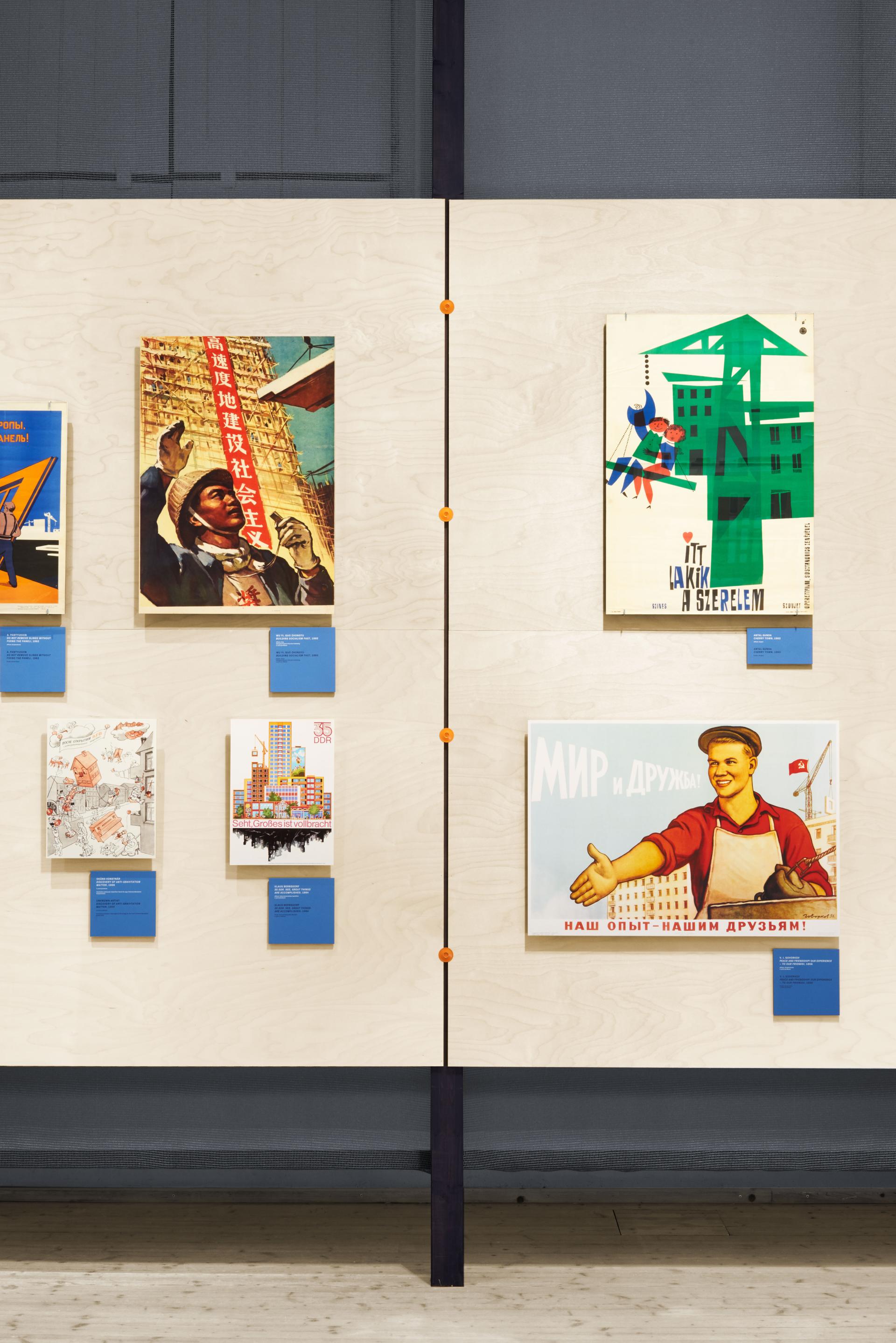 Exhibition display featuring various historical posters related to concrete architecture and urban reconstruction at ArkDes, Stockholm.