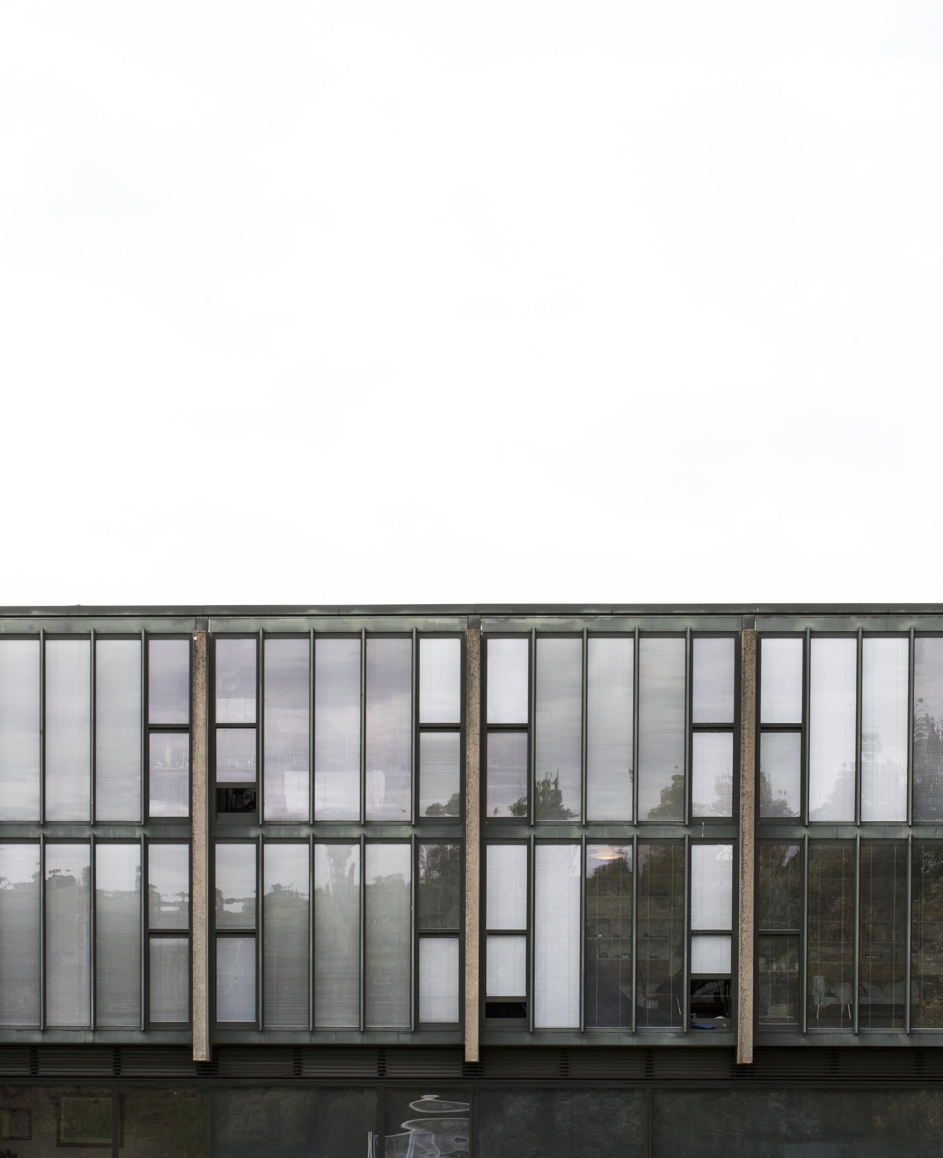 Modern architecture of St Catherine's College, University of Oxford, showcasing large glass panels and distinctive design elements.