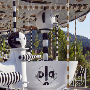 Artistic carousel design by Jaime Hayon featuring playful, abstract characters in black and white, evoking freedom and joy.