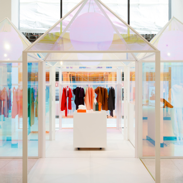 Colorful garments displayed in a playful pop-up installation for Pangaia at Selfridges, showcasing sustainable fashion.