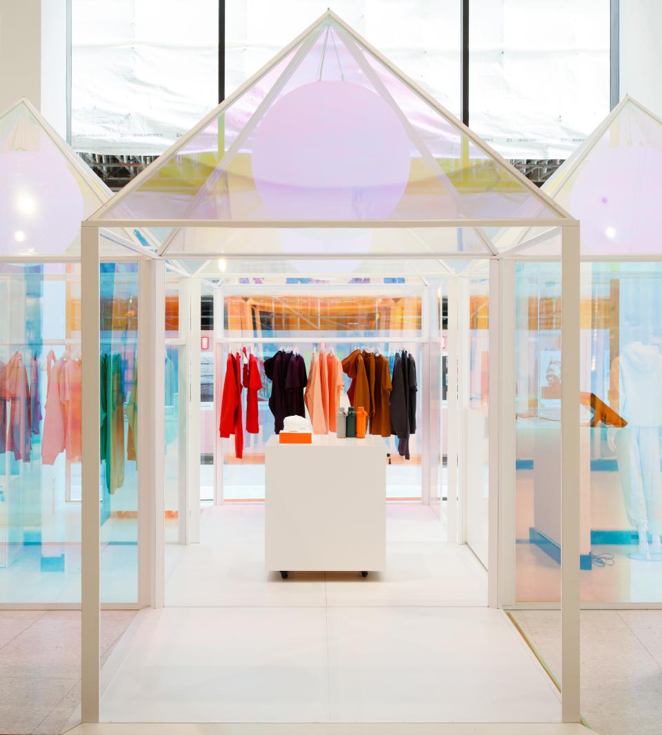 Colorful garments displayed in a playful pop-up installation for Pangaia at Selfridges, showcasing sustainable fashion.