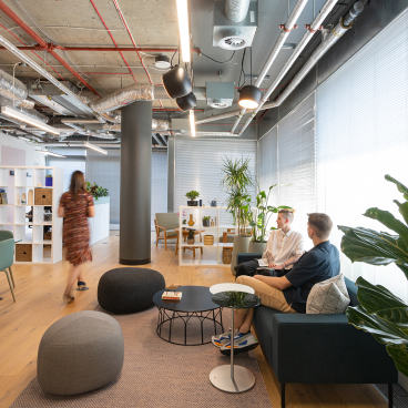 Modern, inviting interior of a community space for First Love Foundation, showcasing plants and cozy seating arrangements.