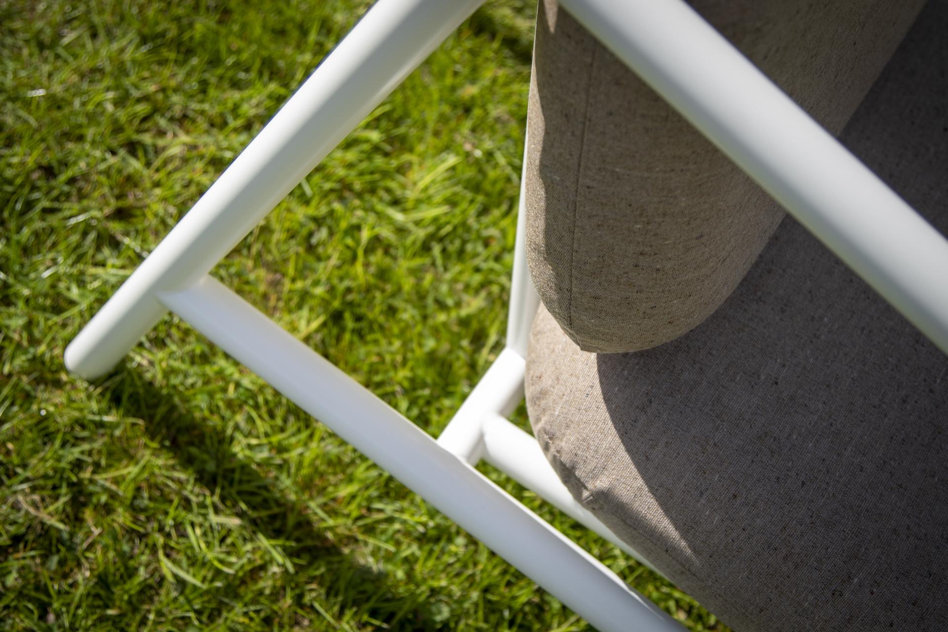 Outdoor seating furniture sits on lush green grass, highlighting stylish design trends for future outdoor hospitality settings.