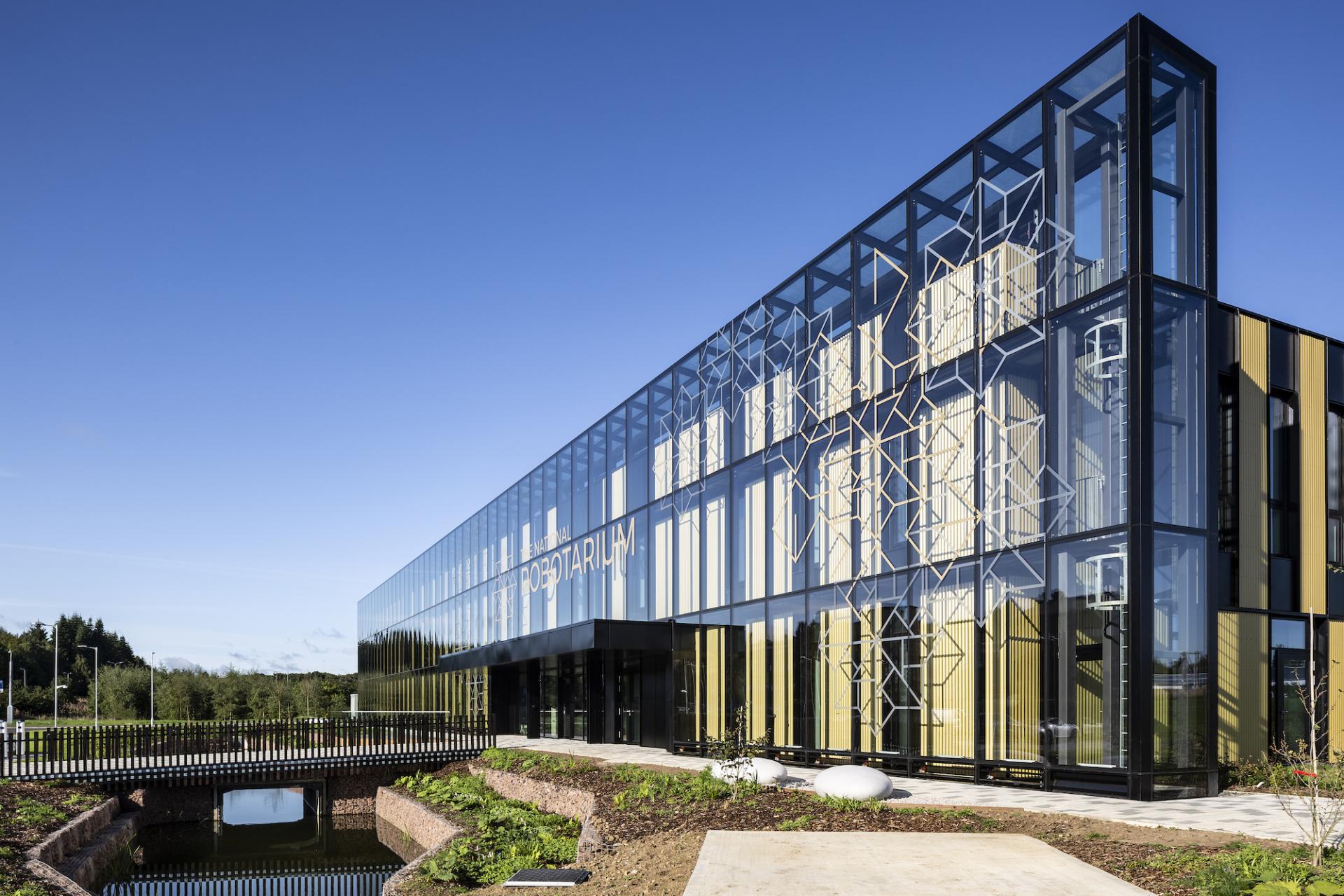 Modern architectural design of the National Photonarium with glass façade, landscaping, and natural surroundings in Scotland.