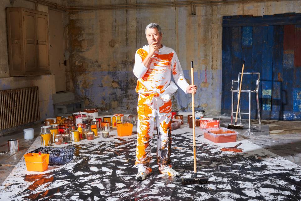 Artist surrounded by paint and tools in a colorful studio, reflecting Forbo's innovative design collaboration with Philippe Starck.