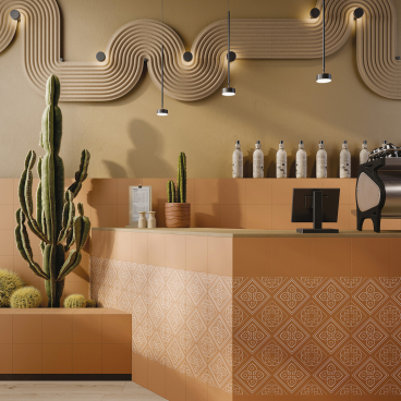 Modern café interior featuring Grestec's Silence Collection porcelain tiles, stylish plants, and elegant lighting.