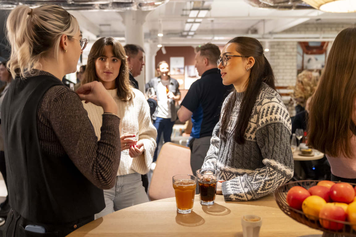 Guests engage in conversation at the Material Source Studio celebration, showcasing community interaction and creative collaboration.