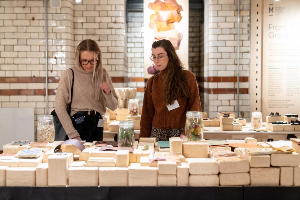 Visitors explore biomaterials displayed at the "From The Ground Up" exhibition in Material Source Studio.